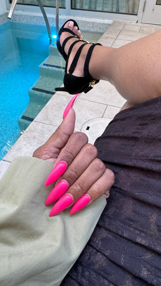 matte pink xl stiletto nails poolside with black strappy heels