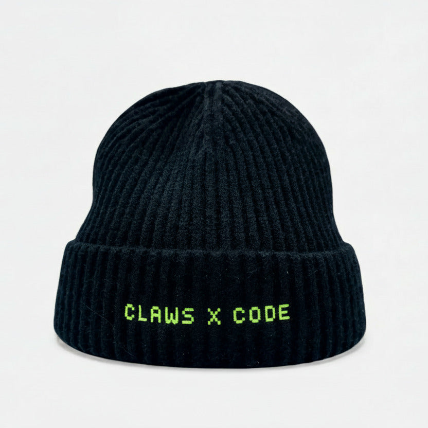 Black beanie with CLAWS X CODE 8-bit text on a knit fisherman's beanie.